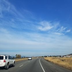 Road by sea against blue sky