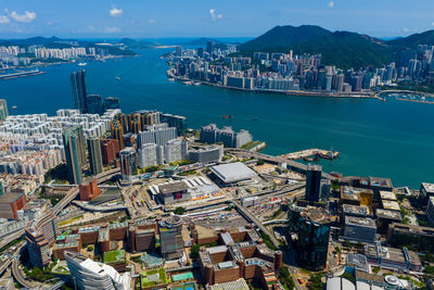 High angle view of city by sea and buildings against sky