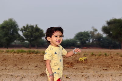 Portrait of smiling girl standing on land