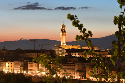 Illuminated buildings against sky during sunset