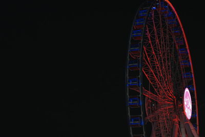 Low angle view of illuminated ferris wheel against sky at night