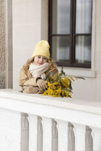 A girl  with a bouquet of mimosa in her hands. spring, international women's day march 8