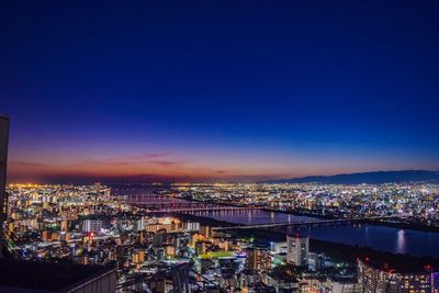 High angle view of illuminated cityscape against sky at dusk