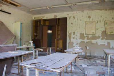 Empty chairs and table in abandoned building