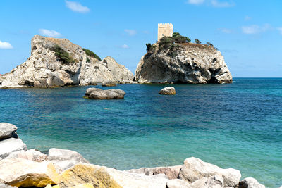 Scenic view of rocks in sea against sky