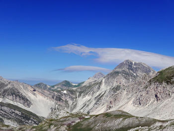 Scenic view of snowcapped mountains against blue sky