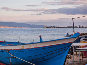 Boats moored at harbor against sky