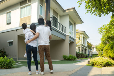 Men standing outside house against building