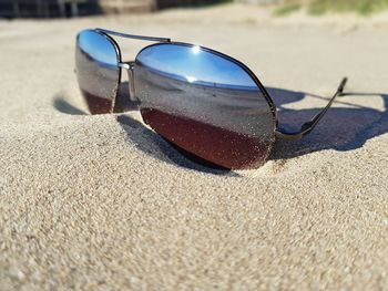 Close-up of sunglasses on sand