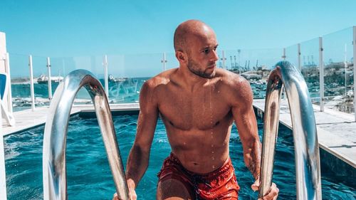 Man standing by swimming pool