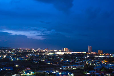 High angle view of illuminated buildings against sky at night