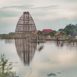 Scenic view of river by building against sky