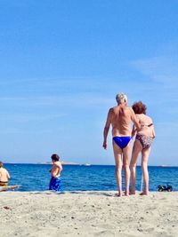 Full length of friends on beach against sky