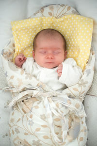 Cute newborn baby sleeping in swaddle wrap with smile on her face. newborn theme