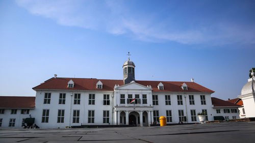 View of buildings in city against blue sky