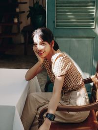 Portrait of smiling young woman sitting outdoors