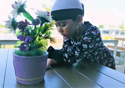 Woman looking at potted plant