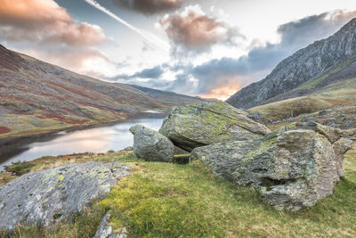 Scenic view of stream amidst rocks against sky