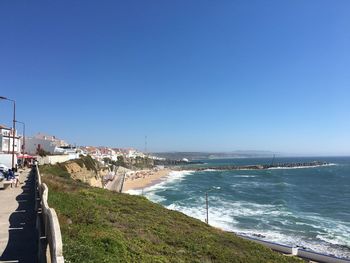 Scenic view of beach against clear blue sky