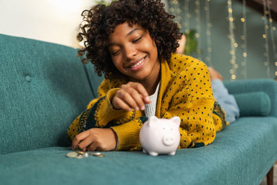 Portrait of young woman sitting on sofa at home