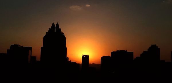 Silhouette of buildings against sky during sunset