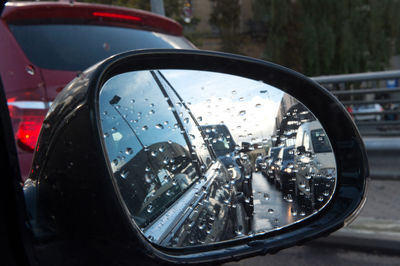 Close-up of wet car side-view mirror