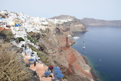 High angle view of townscape by sea against clear sky