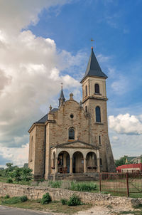 Cloudy landscape with stone church. catholic church on background of cloudy sky.