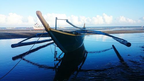 Boat moored at beach against sky