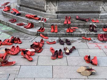 High angle view of red shoes in public on footpath in city, artistic