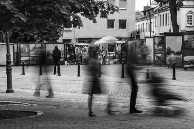 Defocused image of people walking on cobbled street