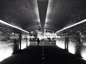 People in illuminated underground walkway