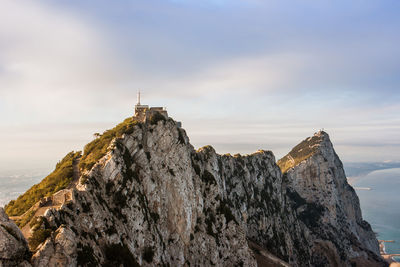 Rock formations on cliff against sky