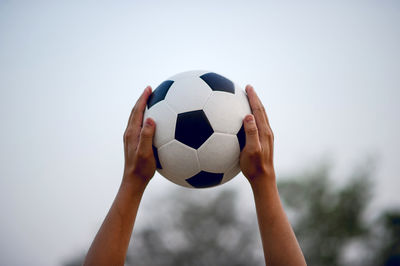 Close-up of hand holding soccer ball