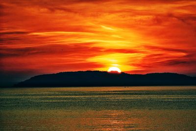 Scenic view of silhouette landscape against dramatic sky during sunset