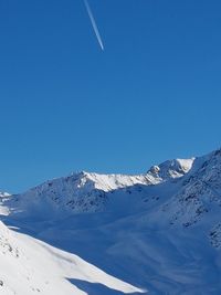 Scenic view of snowcapped mountains against clear blue sky