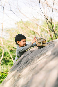 Portrait of young woman sitting on rock