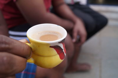 Midsection of man holding coffee cup