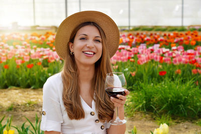 Portrait of young woman drinking wine in park