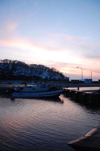 Boats in sea at sunset