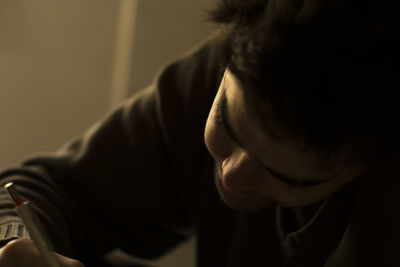 Close-up of man writing with pen