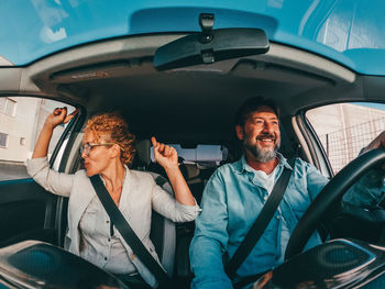 Happy couple sitting in car