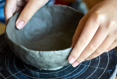 Close-up of person holding clay bowl