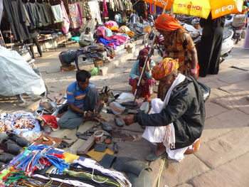 People sitting on street in city