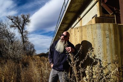 Portrait of men standing by plants against sky