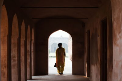 Rear view of man standing in corridor