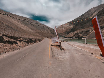 Road by mountain against sky