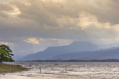 Scenic view of land and mountains against sky