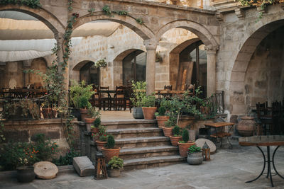 Empty chairs and tables against building