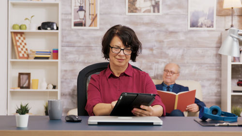 Young woman using laptop while sitting on table